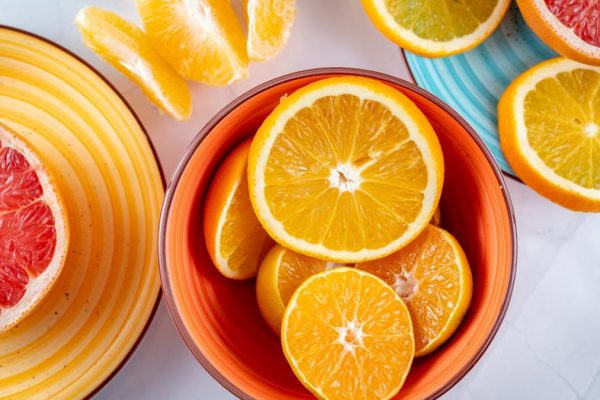 Citrus slices creatively arranged in ceramic bowls, showcasing a vivid and fresh presentation of grapefruits and oranges.